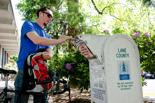 Jason Randall, 26, places his mail-in ballot in a drop box outside the Lane County Elections Office in Eugene, Ore. Michael Ciaglo/News21