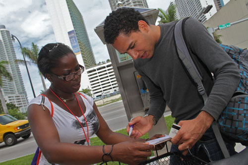 Barbara Johnson, a National Council of La Raza voter registration canvasser, assists Quilvio Rodriguez, 26, of Miami, with his registration application on May 31, 2012, outside a grocery store in Miami’s Little Havana neighborhood. Photo by Ethan Magoc/News21